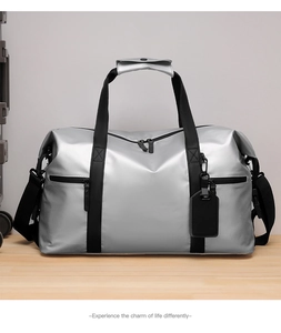 Detail of silver travel bag with waterproof coating, sturdy black straps and metal zippers