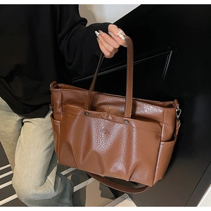 Détail d'un sac cabas vintage marron avec texture froissée et poches fonctionnelles