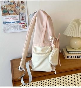 Detail view of pink student backpack showing wide mesh straps and detachable coin purse