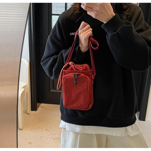 Rote Nylon-Beuteltasche mit Kordelzug und Reißverschlusstasche als Umhängetasche getragen