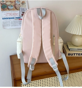 Detail view of pink backpack featuring anti-theft hidden zipper pocket and padded straps