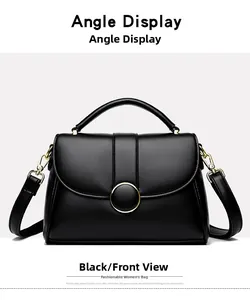 Detailed front view of black leather handbag featuring a golden circular buckle and handle