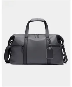 Close-up of gray travel bag with waterproof fabric, dual handles and leather luggage tag