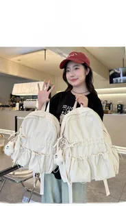 Size comparison of white school backpack with cute bow and plush doll on a model