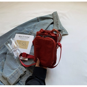 Détail du sac bandoulière imperméable marron rouge avec cordon et poches zippées