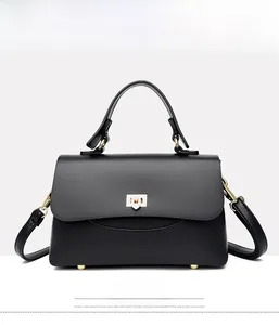 Front view of black lychee leather handbag with gold metal lock and protective feet