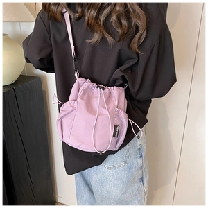 Detailed back view of purple nylon drawstring bucket bag with side mesh pocket