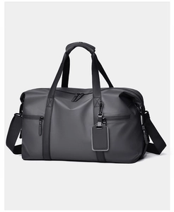 Close-up of waterproof travel bag showing reinforced handles and detachable shoulder strap