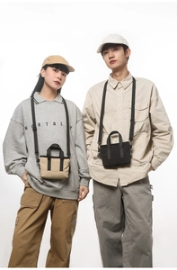 Mini nylon tote bag with dual handles and adjustable shoulder strap shown on models
