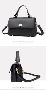 Detail view of black lychee leather handbag featuring golden hardware and flap closure
