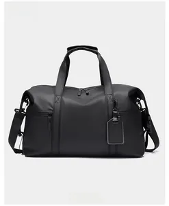 Front view of black waterproof travel bag with reinforced handles and shoulder strap