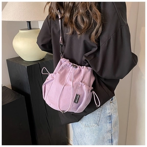 Detail view of lavender nylon bucket bag with drawstring closure and mesh side pocket