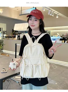 Detail of off-white backpack with drawstring pockets and cute plush bear accessory