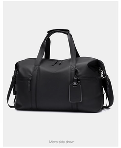 Micro side show of the matte waterproof black travel duffel bag with buckled side straps