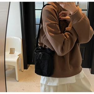 Sac bandoulière en nylon pour téléphone et gourde porté par un mannequin au quotidien