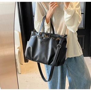 Détail du sac cabas noir avec texture en cuir froissé unique et rivets métalliques