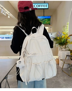 Detail view of large capacity canvas backpack with cute bowknot and plush cloud pendant