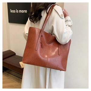 Detail view of brown vintage tote bag showing retro leather texture and shoulder strap fit