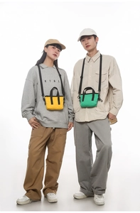 Mini borse tote in tela giallo e verde brillante mostrate in scatto a due modelli