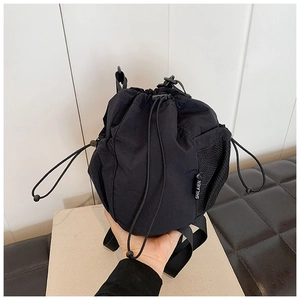 Close-up of lightweight black drawstring bucket bag with mesh side pocket and logo detail