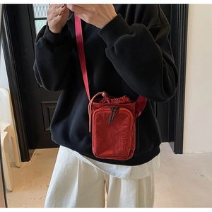Détail du mini sac bandoulière rouge en nylon avec fermeture à cordon et sangle réglable