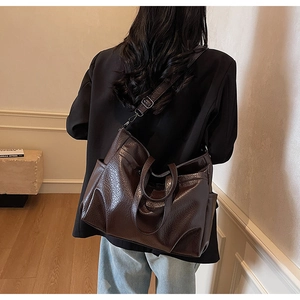 Vue détaillée du sac cabas vintage marron foncé avec texture plissée brillante et poche latérale