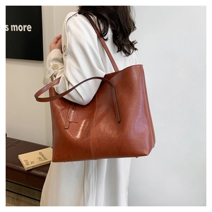 Macro view of vintage brown tote bag texture with long straps and side leather detail
