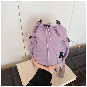 Detail of light purple nylon bucket bag with mesh side pocket and drawstring toggle