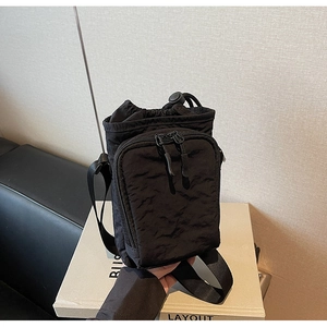Détail macro du sac bandoulière en nylon noir imperméable avec cordon et fermetures