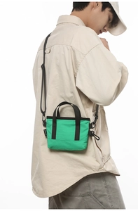 Dettaglio della mini borsa porta cellulare verde smeraldo con tracolla nera rimovibile
