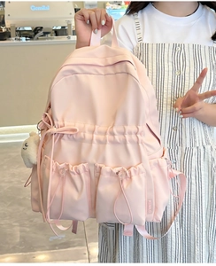 Detail of pink nylon backpack with large capacity and cute plush bear accessory