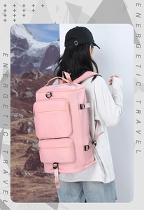 Sac à dos de voyage rose imperméable avec plusieurs poches dans un décor de montagne