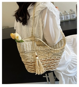 Detalle de bolso tote de paja tejida con borla boho, texturas hechas a mano y encaje