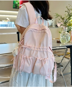 Detailed view of the large capacity pink backpack with drawstring pockets and bear charm