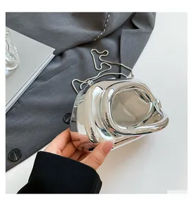 Close-up of a twisted silver evening clutch bag featuring a polished mirror metal finish