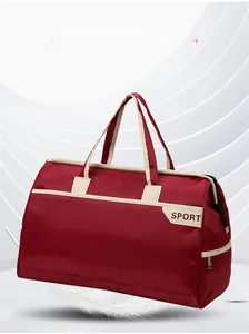 Macro view of burgundy nylon travel bag showing durable cream straps and SPORT logo