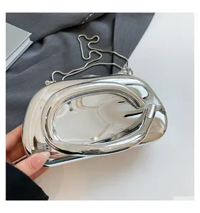 Detail of silver mirror acrylic clutch with large circular handle and metal chain strap