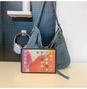 Spacious washed blue denim tote bag shown next to a tablet for size reference