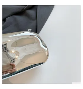 Detail shot of silver mirror acrylic evening bag showing metallic ring and sleek finish