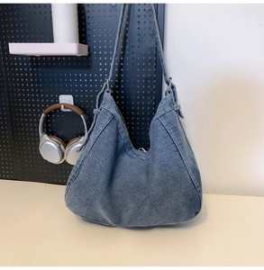 Close-up of soft washed blue denim hobo bag with zipper and double shoulder straps