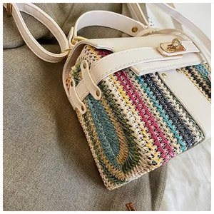 Dettaglio della paglia intrecciata multicolore con finiture in pelle bianca e oro