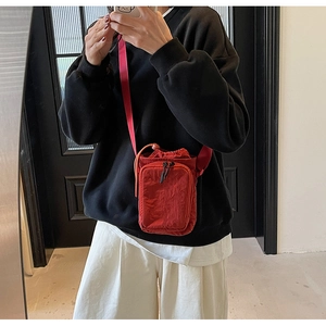 Mini sac à bandoulière en toile rouge avec fermeture à cordon et poche zippée à l'avant