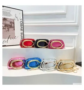 Detail of colorful metallic mirror evening clutch bags with large C-shaped metal handles