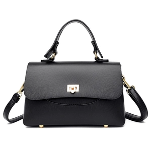 Elegant black pebble leather handbag with gold hardware locks shown on white background
