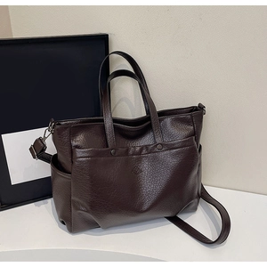 Détail du sac cabas marron foncé avec texture en cuir grainé et boutons pressions