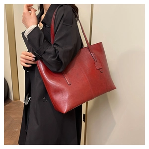 Close-up of vintage red leather tote bag showing high-gloss texture and durable straps
