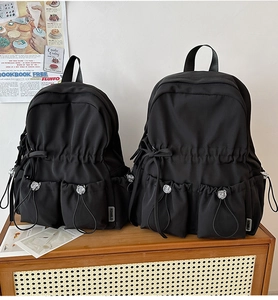 Detail of two black large capacity school backpacks with adjustable buckle pockets