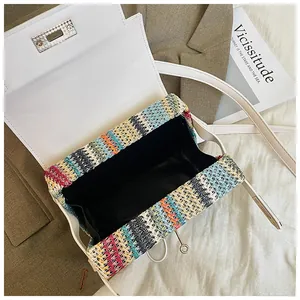 Dettaglio borsa in paglia intrecciata colorata con patta in pelle bianca e chiusura a girello