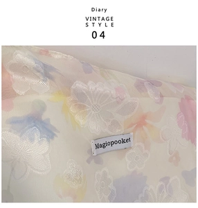 Dettaglio del ricamo floreale vintage e dell'etichetta sul tessuto della borsa tote