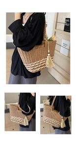 Detalle del bolso tote de paja bohemio con motivos tejidos blancos y borla con cuentas de madera